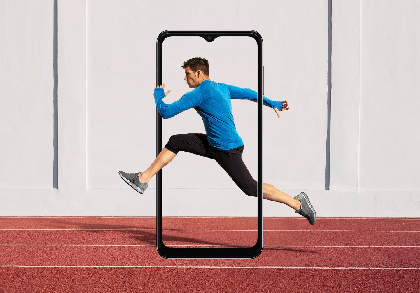 Samsung A04s display specs features a 6.5 inch HD+ screen. The outline of a Galaxy A04s display is set in portrait mode over a running track on a sports field. Onscreen is a man running, striding into the air with his hands and legs extending beyond the frame.