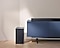 Samsung C series Soundbar is on top of a contemporary TV cabinet along with its matching subwoofer on the side.