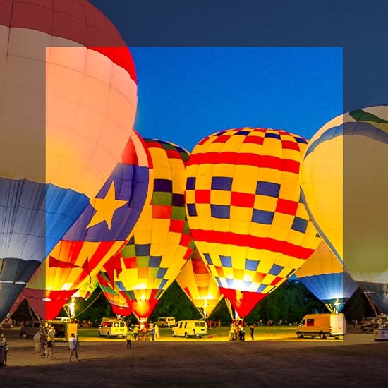 Colorful hot air balloons are on display. The center side is more colorful and has depth compared to the edges. 