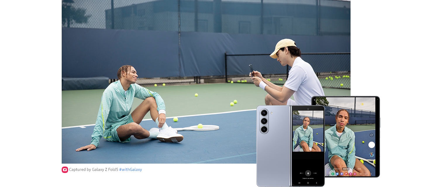  A tennis player poses for a photo on the tennis court. A teammate kneels in front to take the photo with the Rear Camera of an unfolded Galaxy Z Fold5. The photo taker observes the Main Screen while the photo subject observes the Cover Screen. Next, the photo preview is displayed on the Cover Screen as well as the Main Screen.