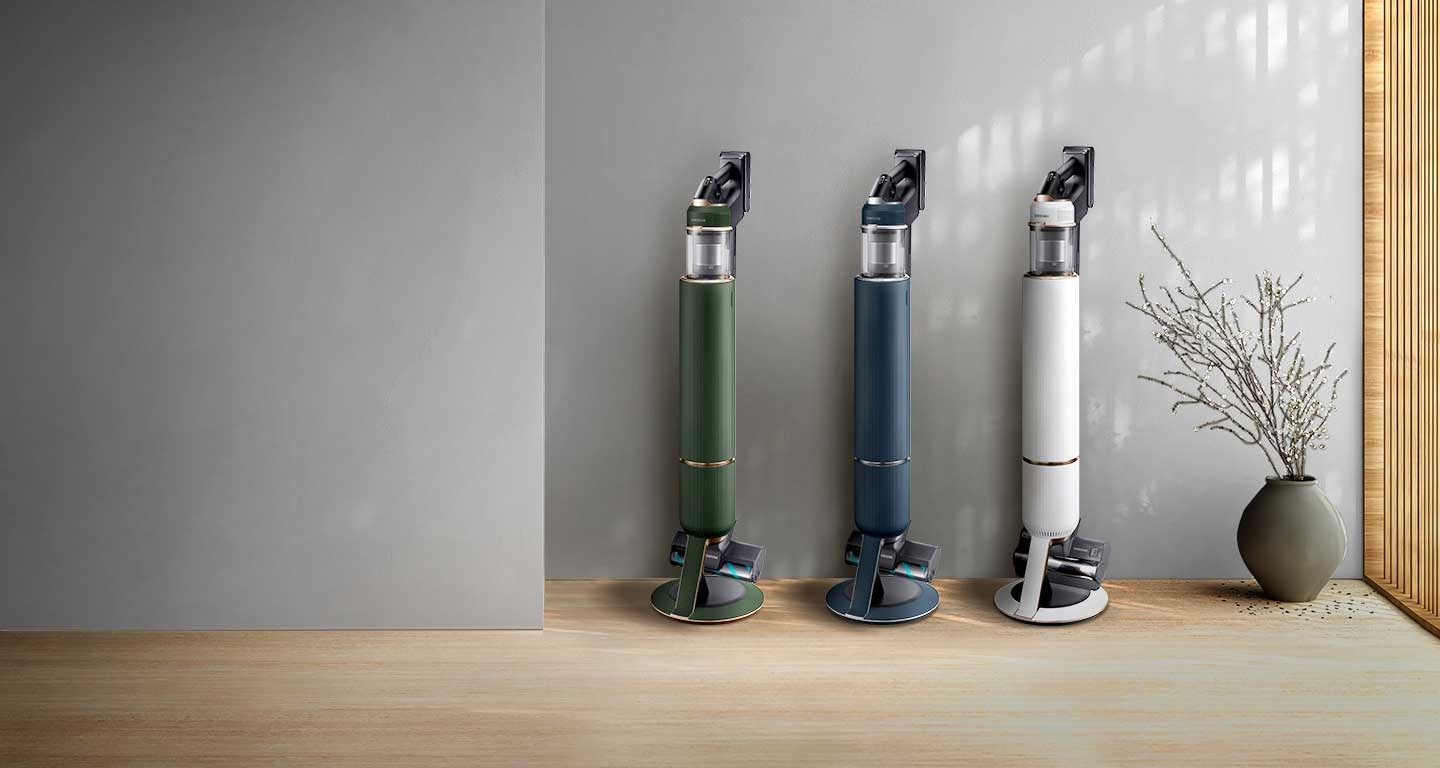 3 Samsung Bespoke Jet Plus models in blue, green, and white stand upright next to a dog and a cat in a modern room.