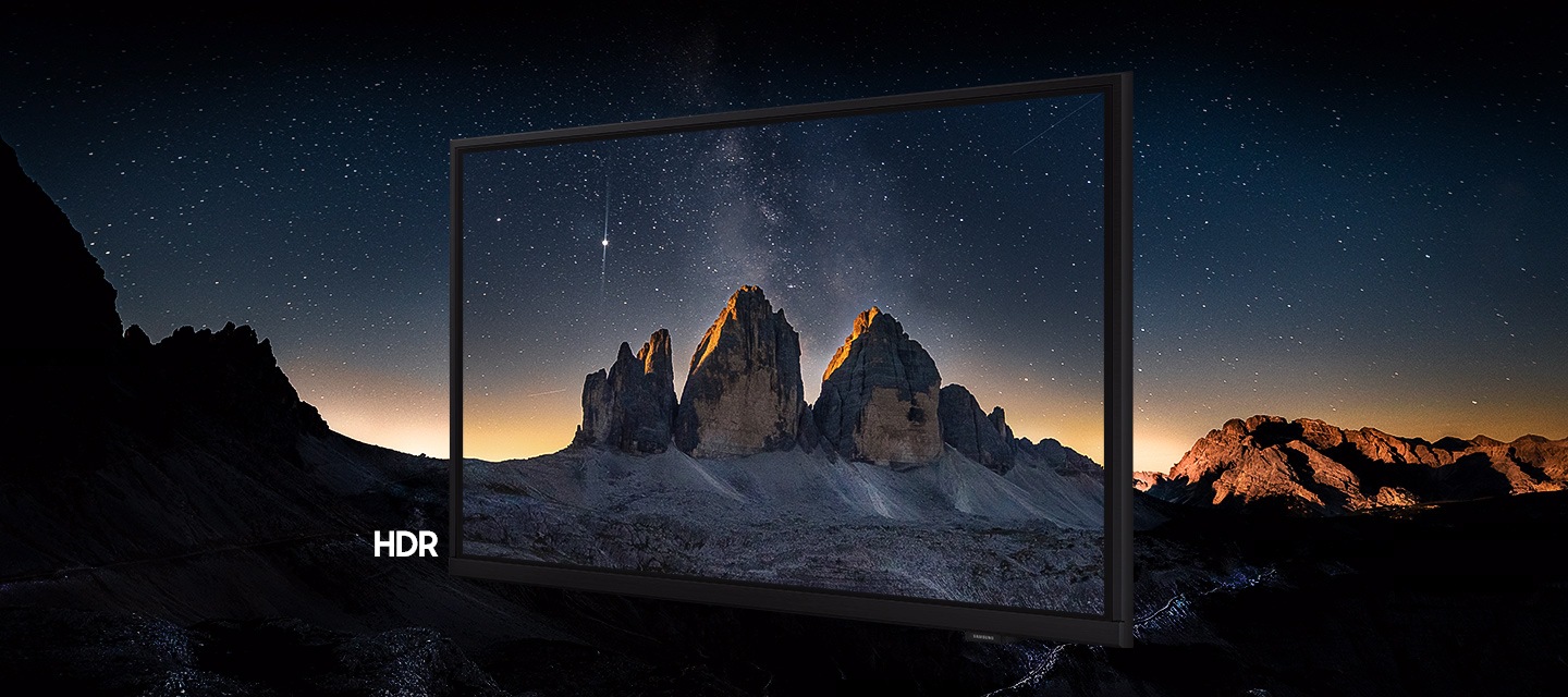A screen shows a mountainous landscape against the night sky in SDR. The image is dark and details are not visible. As the image is transformed into HDR, it becomes brighter with more contrast, revealing hidden details and bringing the landscape to life.