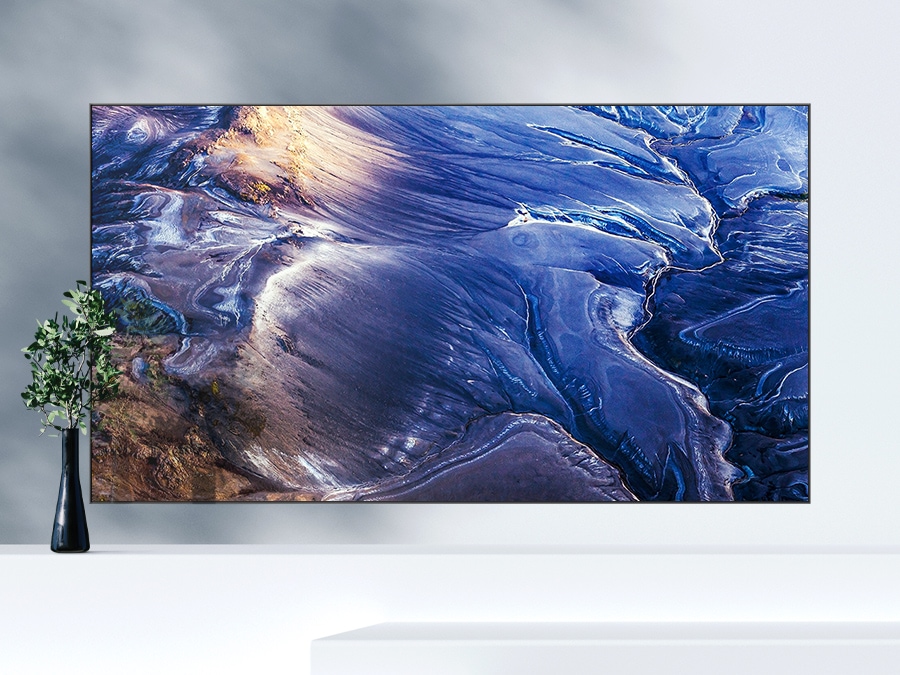 A QLED TV shows matte wave-like blue graphics on the screen with a lot of light reflections.