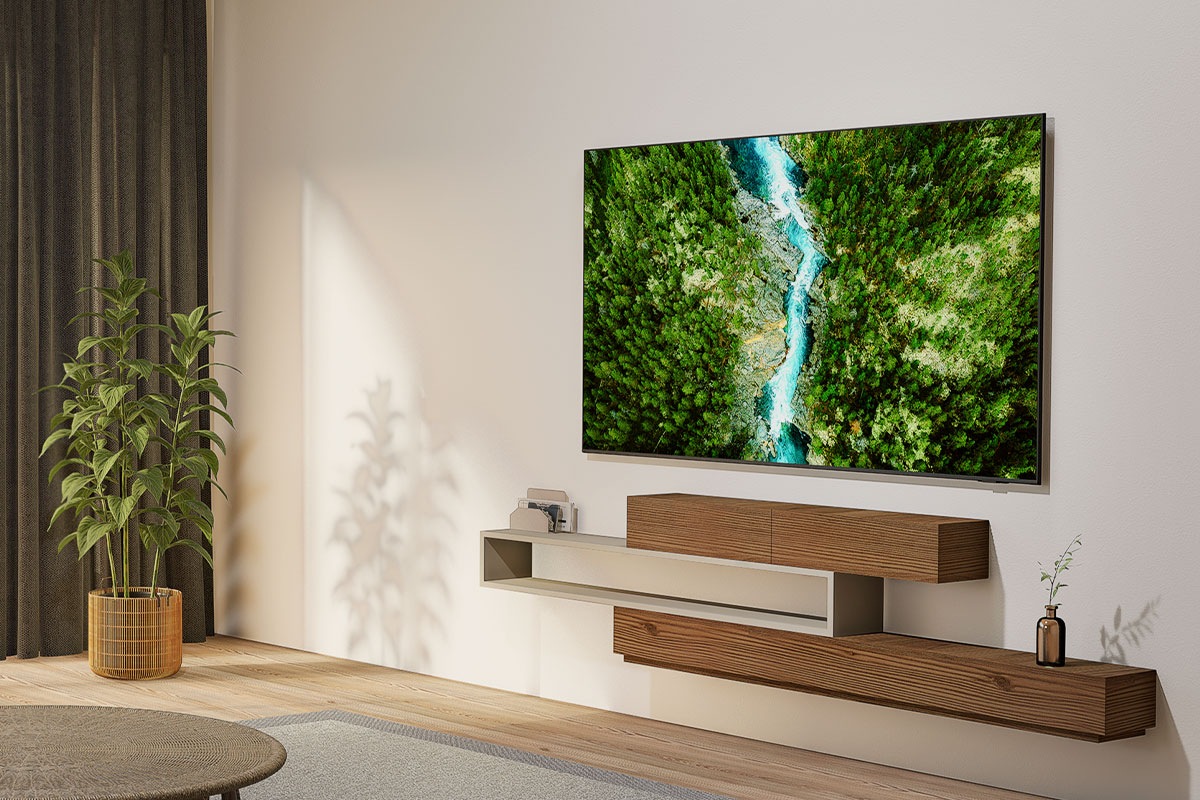 A U8500F is installed on the wall of a living room. The screen displays a top-down view of a lush forest and a flowing river.