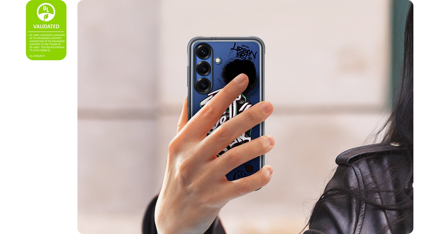 Une personne tient un Galaxy S25 équipé de la Rugged Case. Le téléphone est vu de dos, les mains le long des motifs de la coque. À gauche, une Certification de déclaration environnementale UL indique : « EF-JS931 CONTIENT UN MINIMUM DE 3% DE CONTENU À BASE BIOLOGIQUE, COMPRENANT 9% DE CONTENU À BASE BIOLOGIQUE DANS LE CADRE DE EF-JS931, TESTÉ SELON ASTM D6866-22. UL.COM/ECV ».