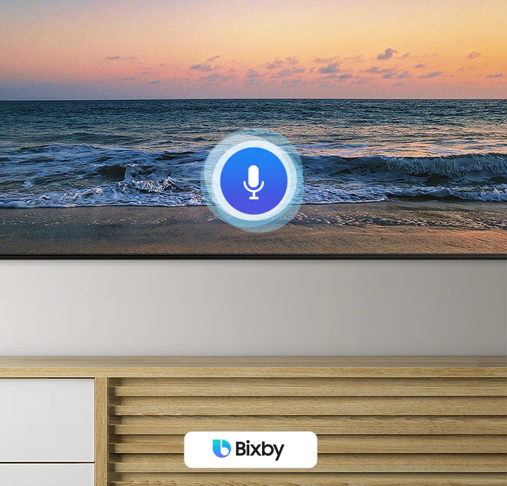 A microphone icon overlays a beach sunset TV screen image, demonstrating UHD TV voice assistant feature.