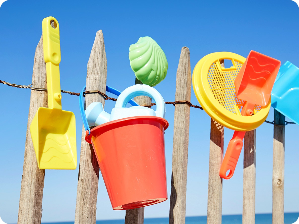1. Beach toys are drying on a wooden fence.