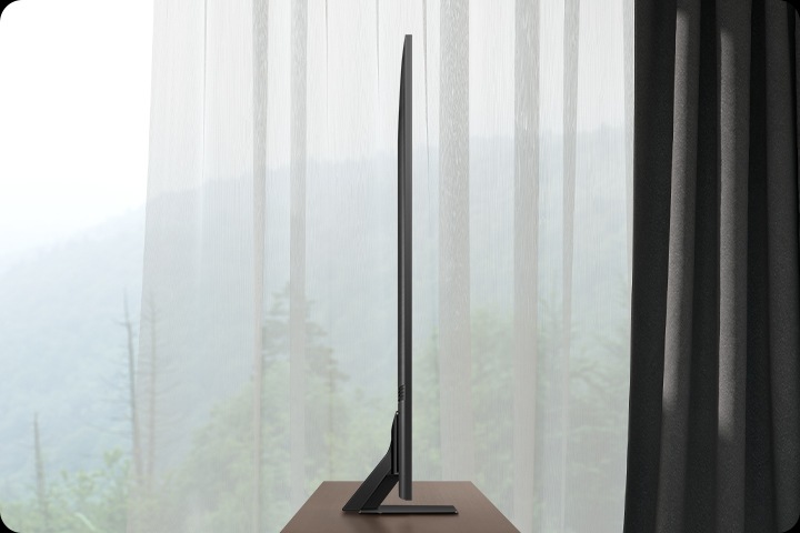 The latest Samsung Neo QLED TV with its design and attachable One Connect box harmonizes with the surrounding furniture in a modern living room.