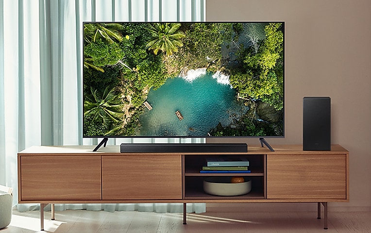 Samsung TV on an entertainment unit with Soundbar and subwoofer.
