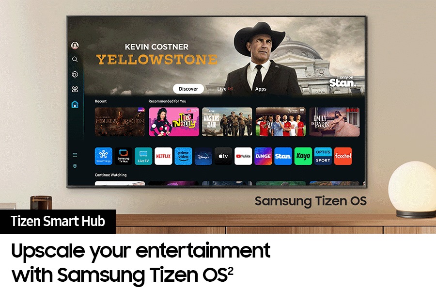 A wall-mounted TV shows popular apps and curated content on the "Samsung Tizen Smart Hub" home menu.