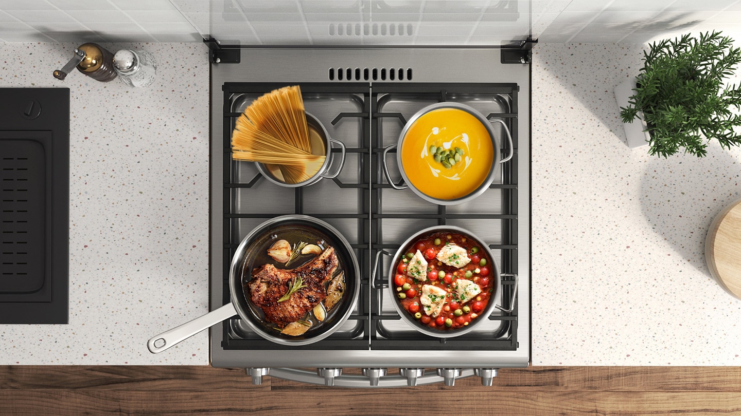 Shows an overhead view of the Wide Cooking Zone, with a variety of different sized pans sitting on the cast iron grates above the four burners and being used to cook different types of food.