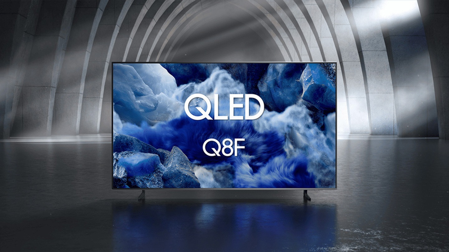 Samsung QLED Q8F TV in a black and white indoor space displays a colorful scene of an otherworldly landscape.