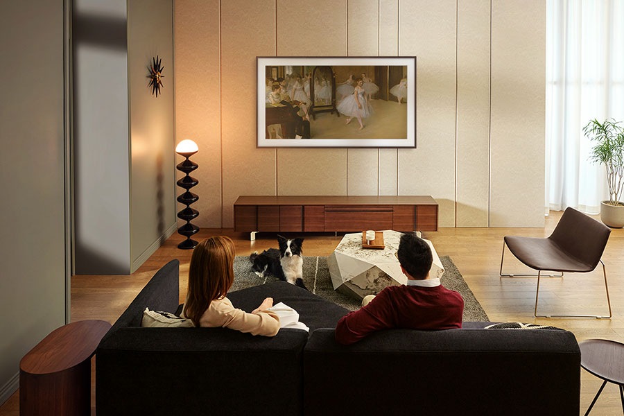 Users enjoy The Frame TV with its Brown Modern Bezel mounted on their living room wall.