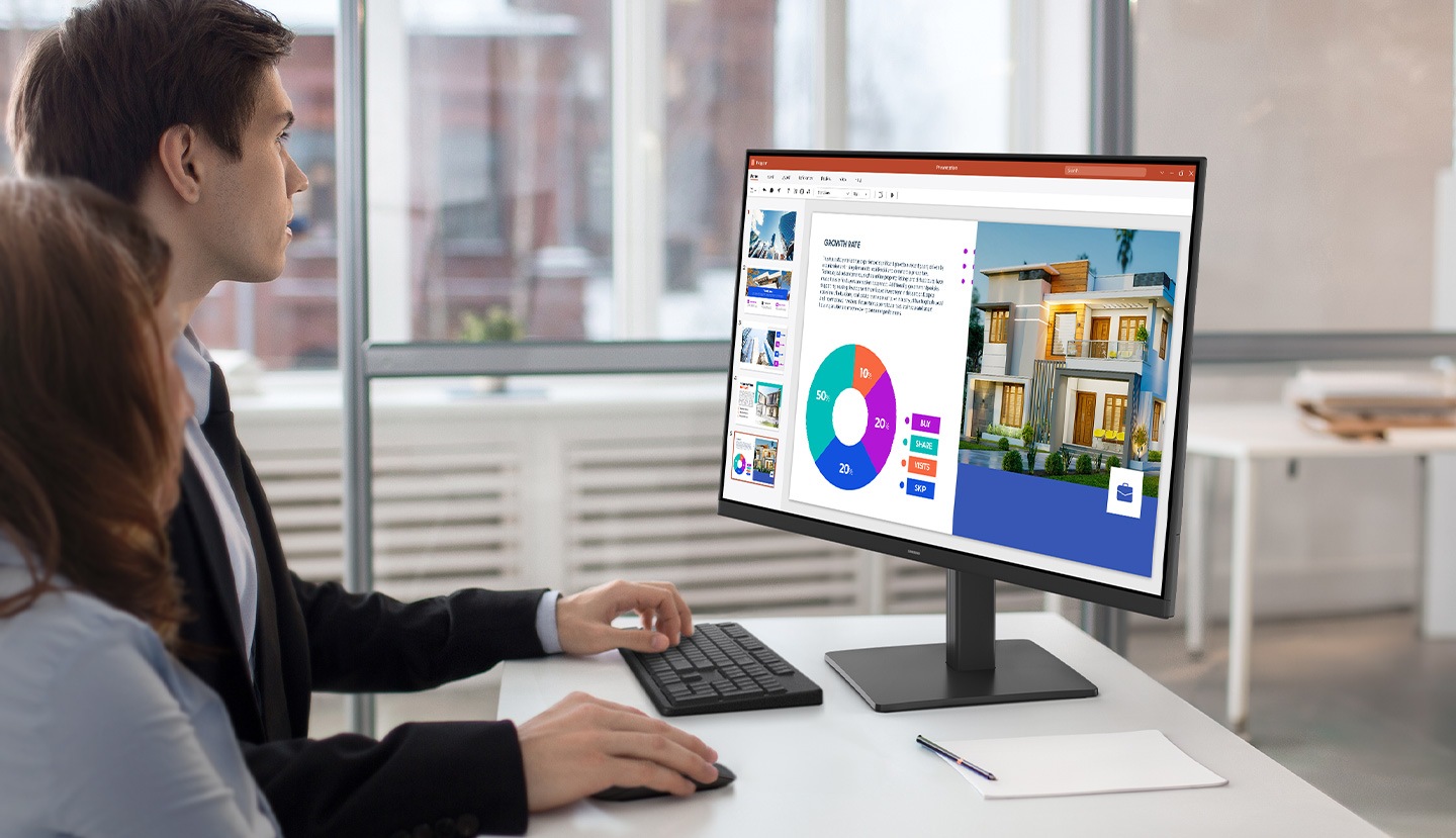 A man and a woman are looking at the monitor screen.