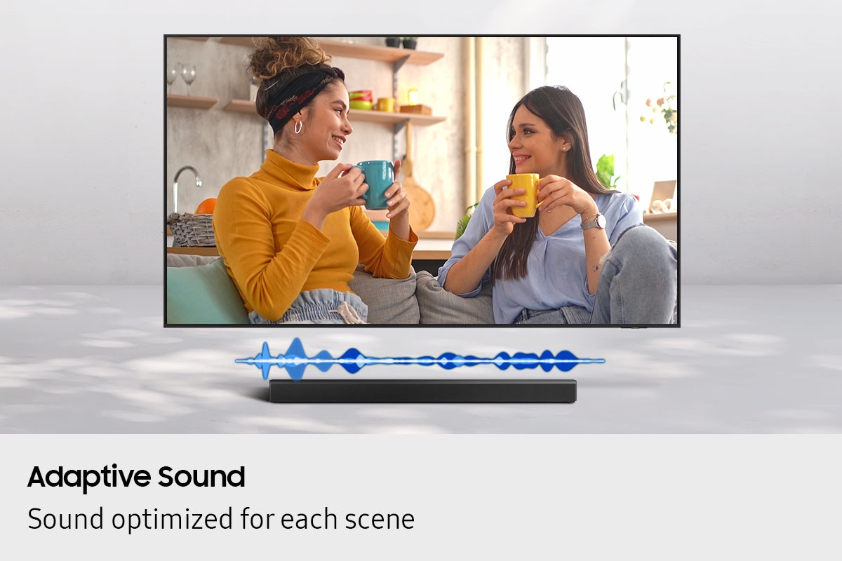 A TV displays a scene of two women chatting. Below it, a soundbar plays the sound at a volume suitable for dialogue.