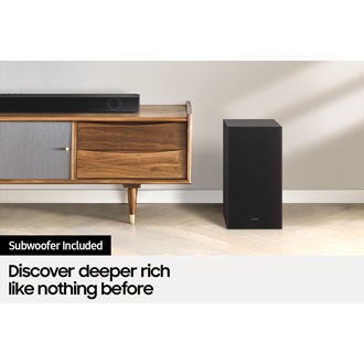 Samsung soundbar B550 is on top of a TV cabinet with its matching subwoofer which is being next to the cabinet.