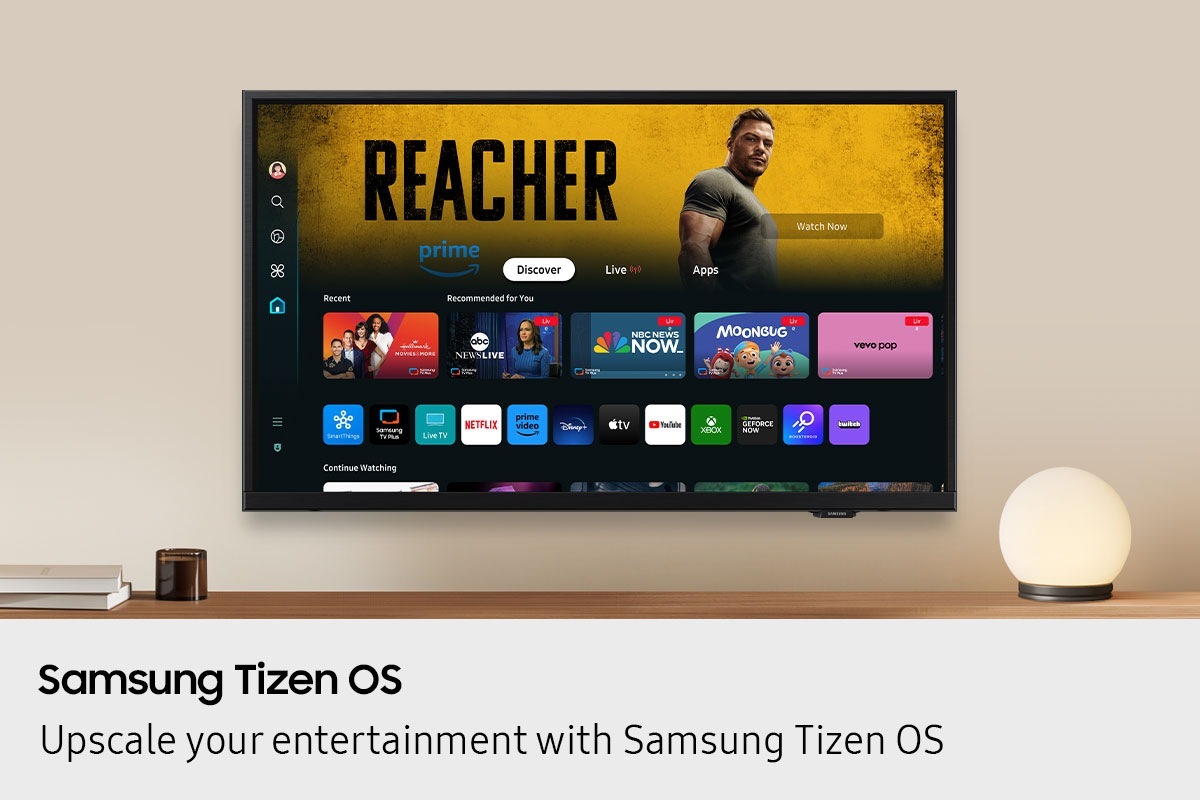 A wall-mounted TV shows popular apps and curated content on the "Samsung Tizen OS" home menu.