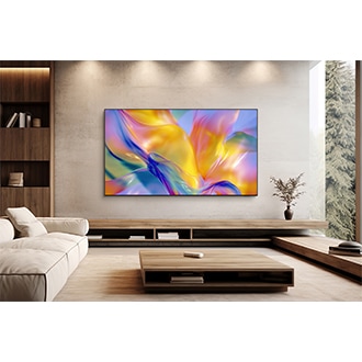 Samsung M90H TV mounted on the wall in a bright living room displaying a vibrant abstract  scene.