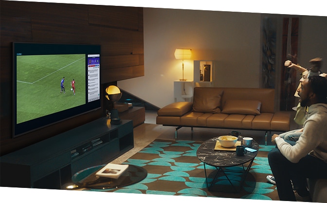 A group of people use QLED TV Multi view feature to enjoy a football match and view play-by-play information at the same time on the same screen.