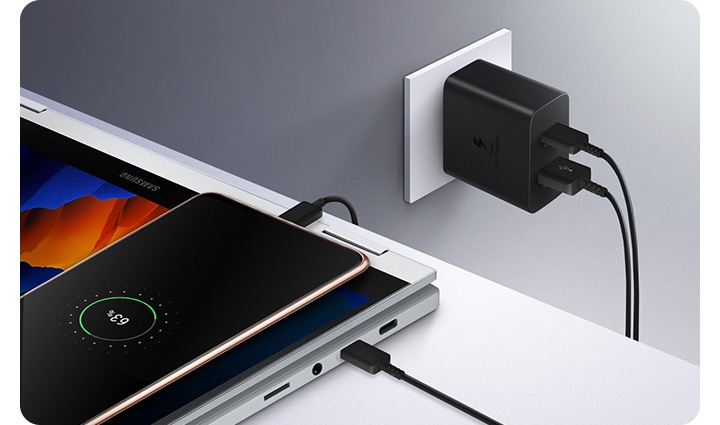 Power Adapter Duo is plugged into the wall outlet to charge both smartphone and a laptop at the same time.