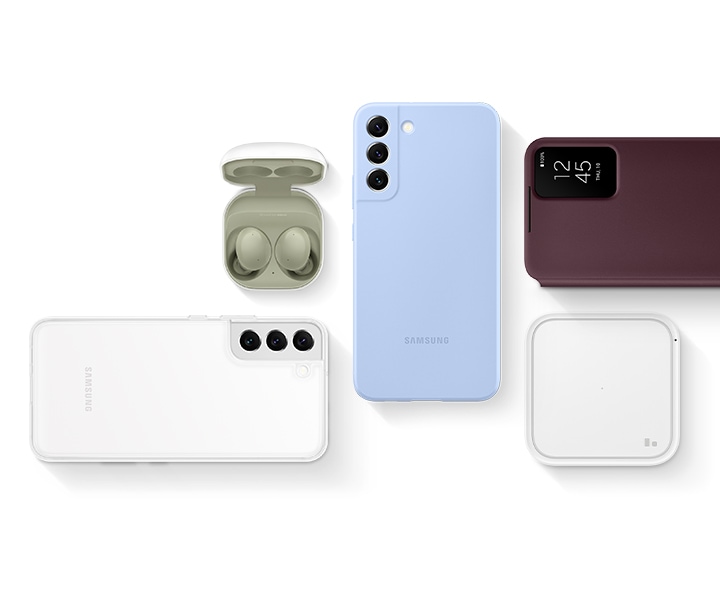 A flat lay with Super Fast Wireless Charger, Galaxy S22 plus seen laying facedown with Clear Cover installed, Galaxy S22 plus seen laying facedown with Silicone Cover installed, Galaxy Buds2 with the buds in an open cradle and Galaxy S22 plus seen laying faceup with the Smart Clear View Cover.