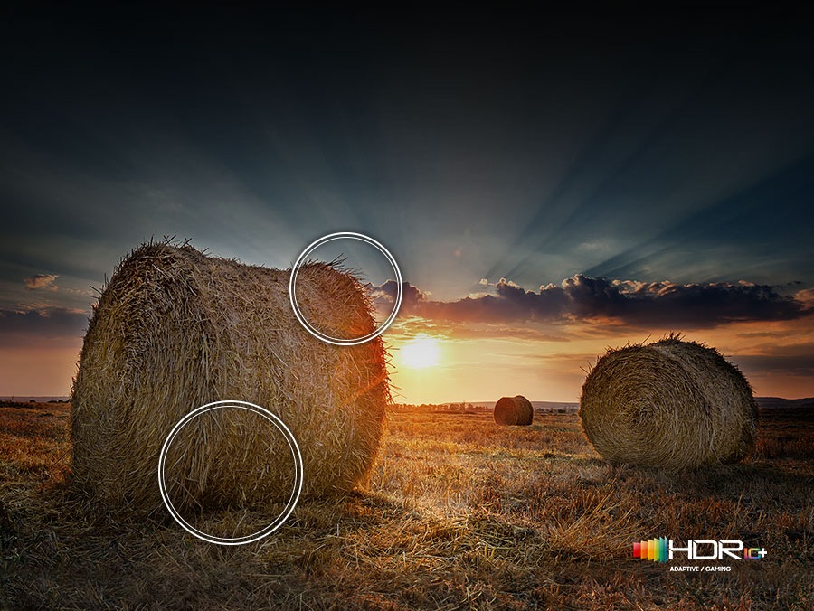 The sun is setting over a wide field with emphasis on a large hay stack. The scene after applying HDR 10+ ADAPTIVE/GAMING technology is much brighter and crisper than the SDR version.