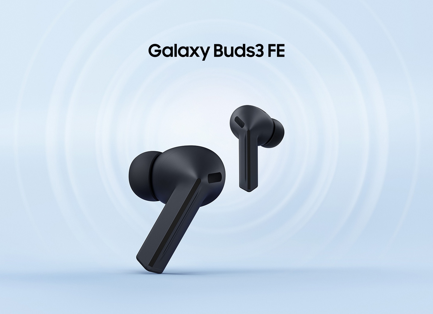 The left Galaxy Buds3 FE earbud in Black facing left in the foreground, with the right earbud slightly behind facing right.