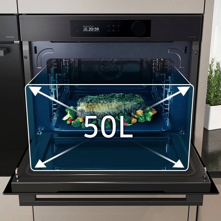 Shows a large tray of food cooking inside the spacious oven with arrows illustrating its 50 liter capacity.