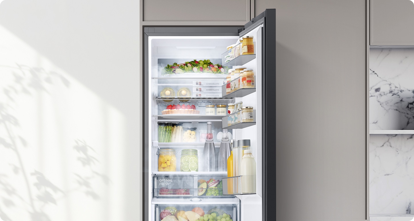 Un frigider la comandă umplut cu diverse alimente este deschis. Aerul rece iese prin orificiile de ventilație din fiecare compartiment pentru a menține temperatura optimă pentru ca alimentele să rămână proaspete.