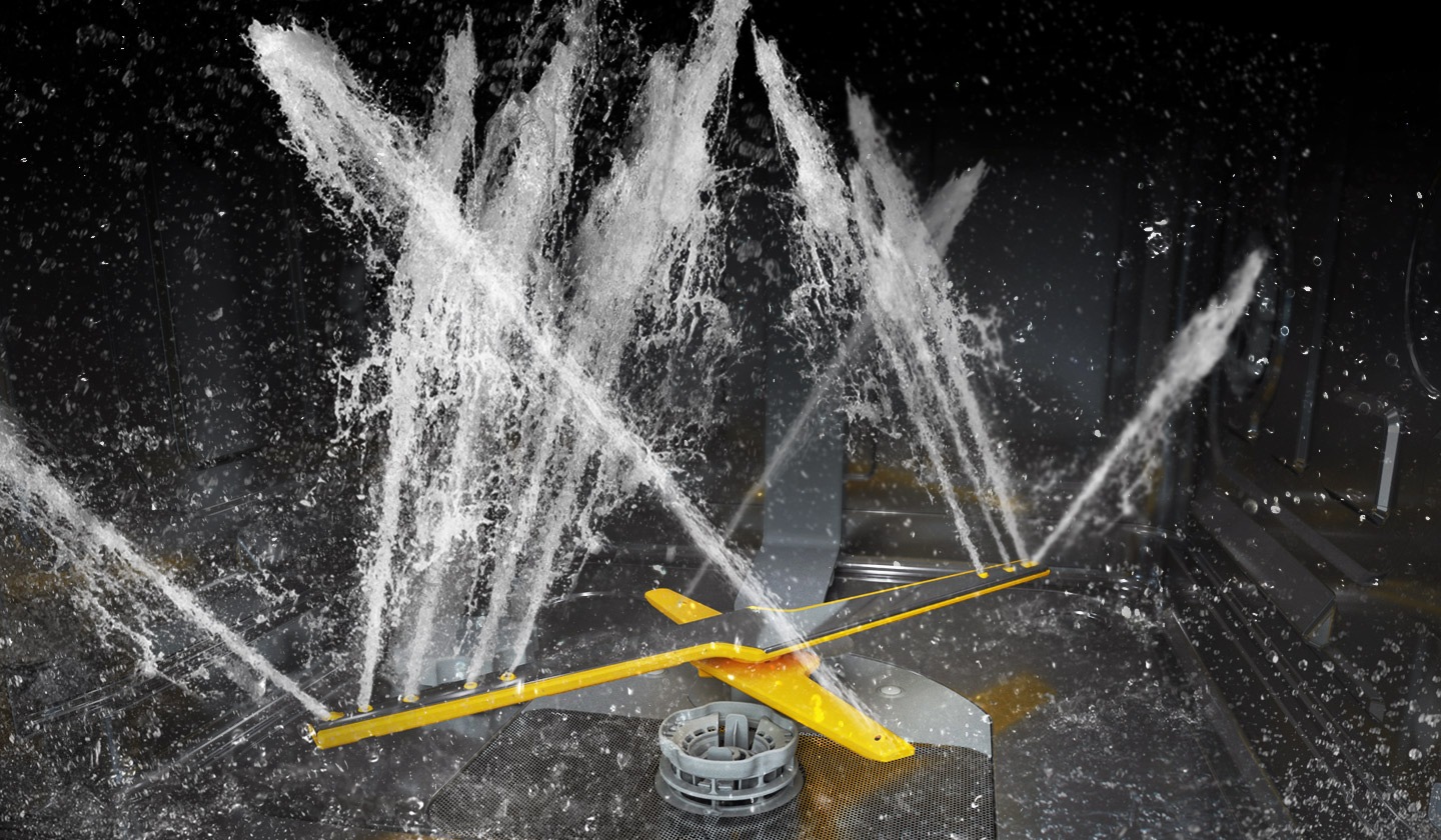 Afișează brațele de spălare duble rotative ale sistemului WaterJet Clean™ care pulverizează jeturi puternice de apă în mai multe direcții.