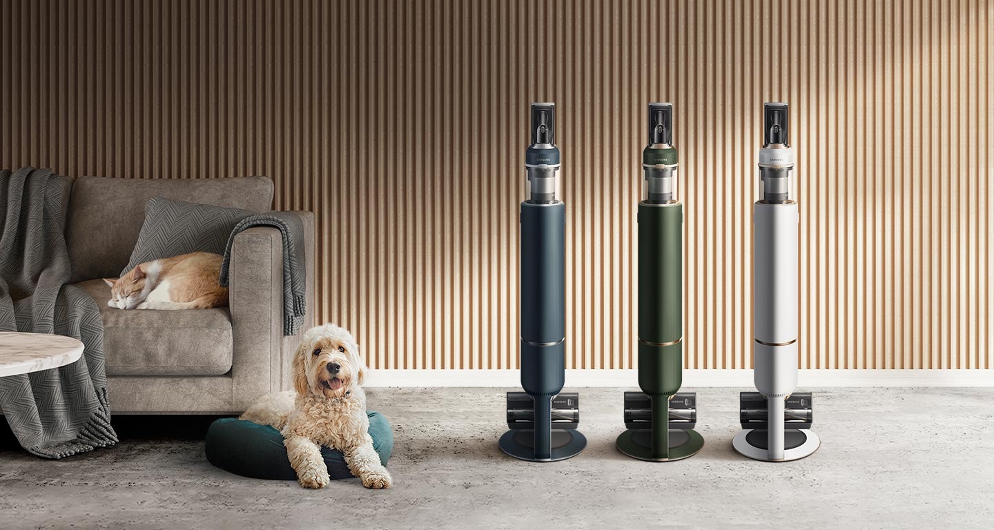 3 Samsung Bespoke Jet plus models in blue, green, and white stand upright next to a dog and a cat in a modern room.