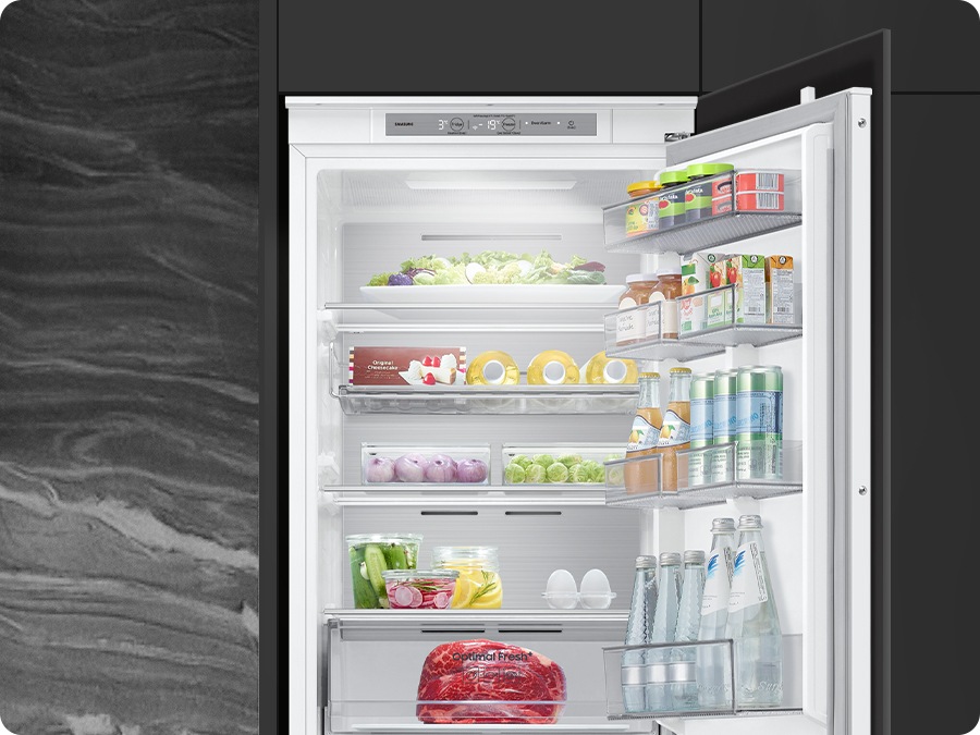The refrigerator's lighting adjusts to match the surrounding environment, revealing its interior.