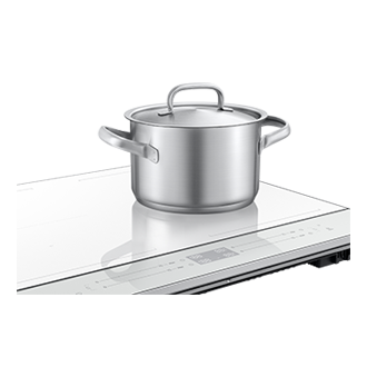 Biała płyta indukcyjna Bespoke SlimFit NZ64B5046KK/U2 - widok po skosie w lewo z garnkiem 