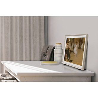 Widok z boku na telewizor The Frame LS03C 32 cale QE32LS03CBUXXH stojący na szafce