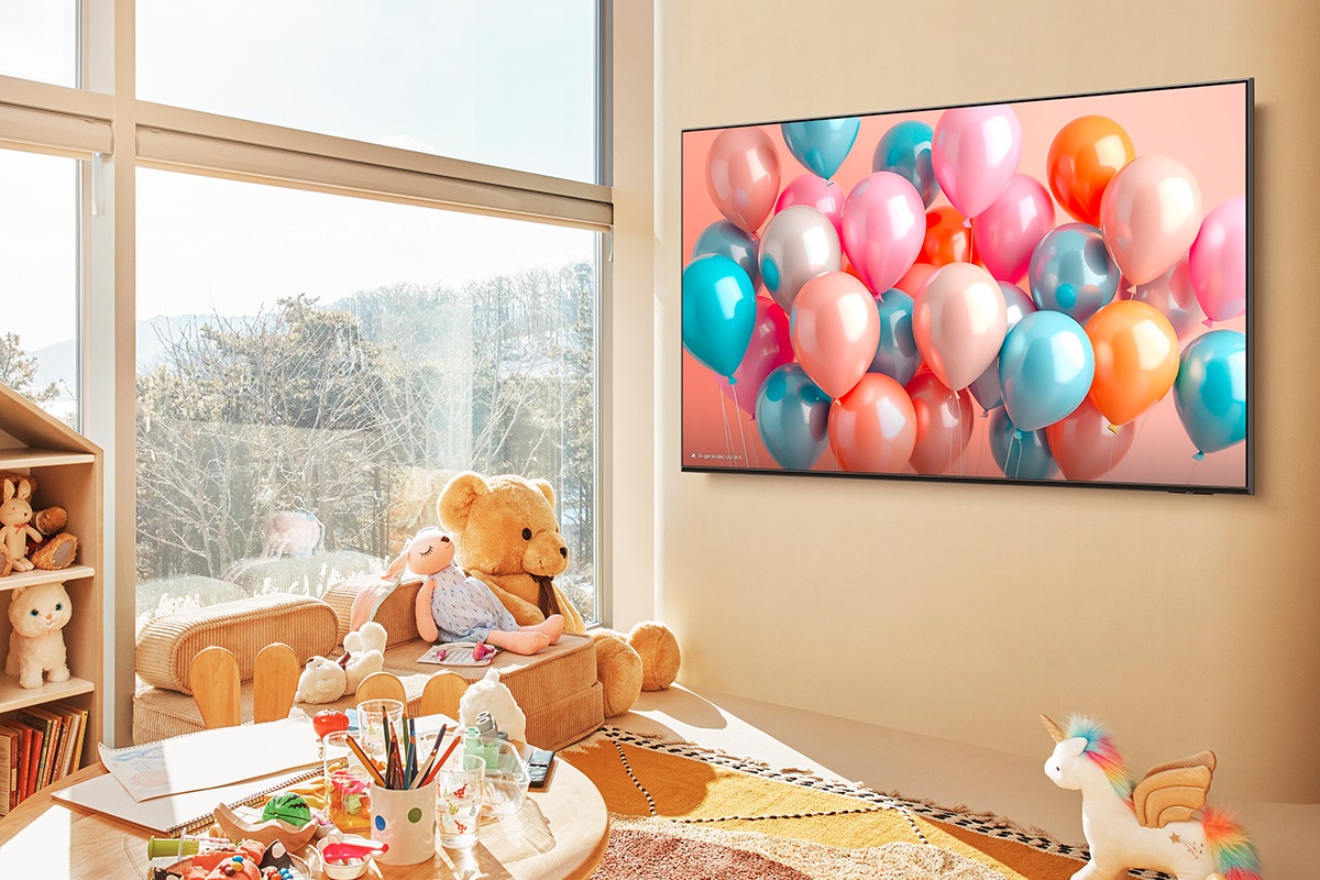 Pokój dzięcięcy z zabawkami i artykułami do rysowania. Na ścianie widać zaieszony telewizor 85" QLED Q7F2 4K Samsung Vision AI Smart TV (2025)