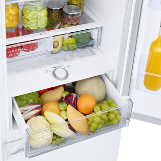Lodówka z dolnym zamrażalnikiem RB38C605CWW/EF z technologią pełnego No Frost - widok wnętrza lodówki z produktami na półkach i wysuniętą szufladą