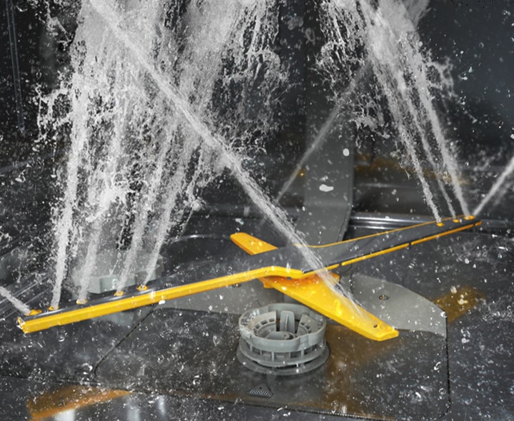 تظهر صورة تعرض ذراعي الغسل المزدوجين الدوّارين في نظام WaterJet Clean™‎ وهما يرشان نفثات ماء قوية في اتجاهات متعددة.