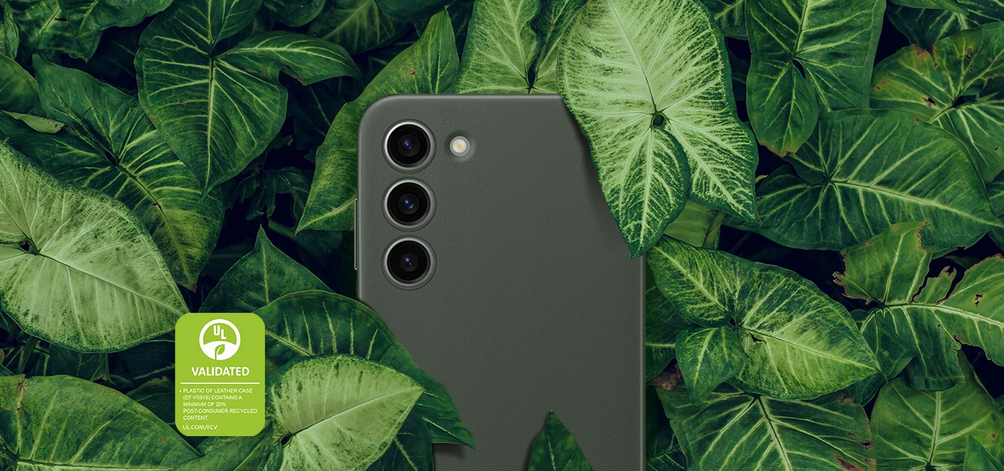 Показан е изглед отзад на Galaxy S23+ с кожен калъф, заобиколен от дебели зелени листа. Текстът е: ПЛАСТМАСАТА В КОЖЕНИЯ КАЛЪФ (EF-VS916) СЪДЪРЖА ПОНЕ 20% РЕЦИКЛИРАНО СЪДЪРЖАНИЕ СЛЕД КОНСУМАЦИЯ.