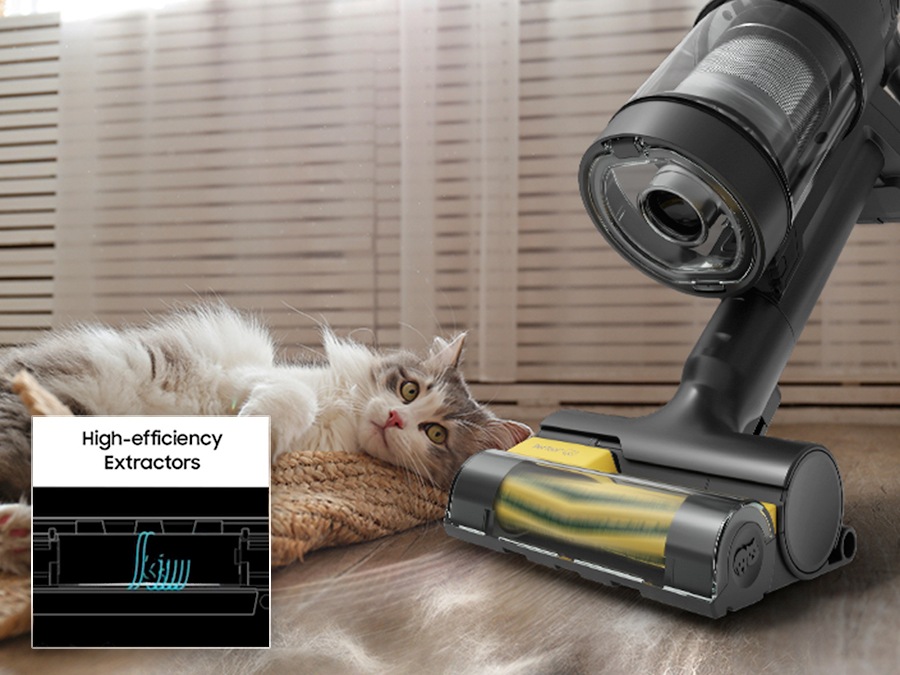 The 'Bespoke Jet AI Ultra' with Pet Tool+ cleans the cat's fur on the floor next to the white cat lying on the carpet. The rubber nozzle and bristles of the brush are a high- efficient extractors that sucks up all pet hair. It shows an animation of cutting and sucking pet hair.