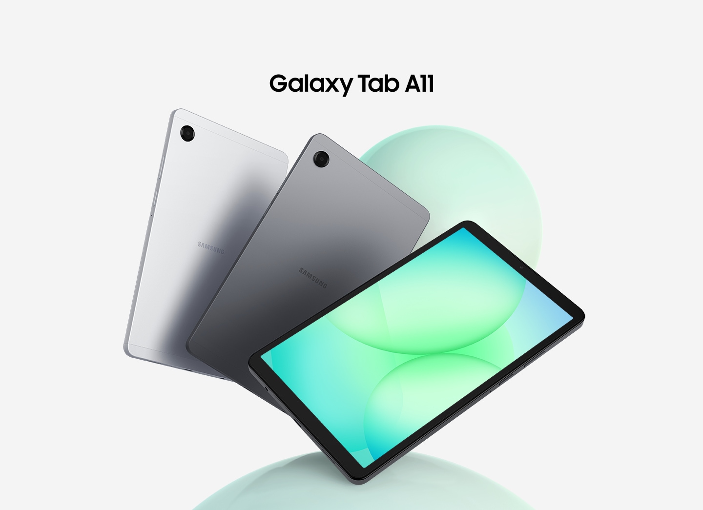 Three Galaxy Tab A11 tablets are arranged in a fan layout. The first two on the left show their backs in silver and gray, while the front-facing tablet displays a greenish circular patterned graphic on its screen. Above the tablets, the text reads 'Galaxy Tab A11'.
