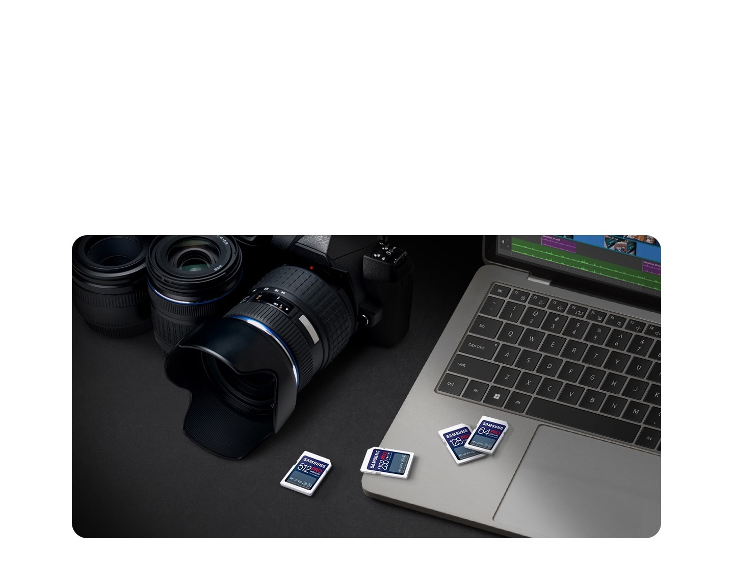 Professional photographer's creative workstation with both laptop and digital camera in view. A series of four SD cards of various capacities are placed over and beside the laptop.