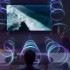A person is sitting in front of a QLED TV as sound waves fill the room with 3D surround sound.