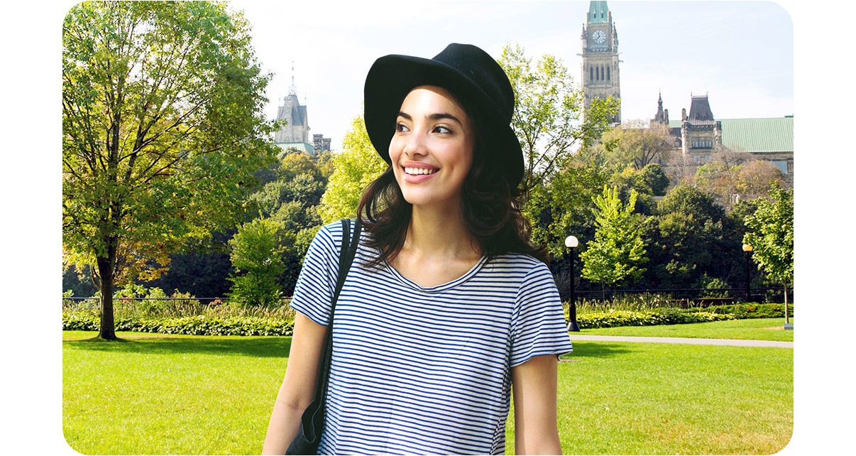 A woman is in the park where lots of trees as a background seem clear.