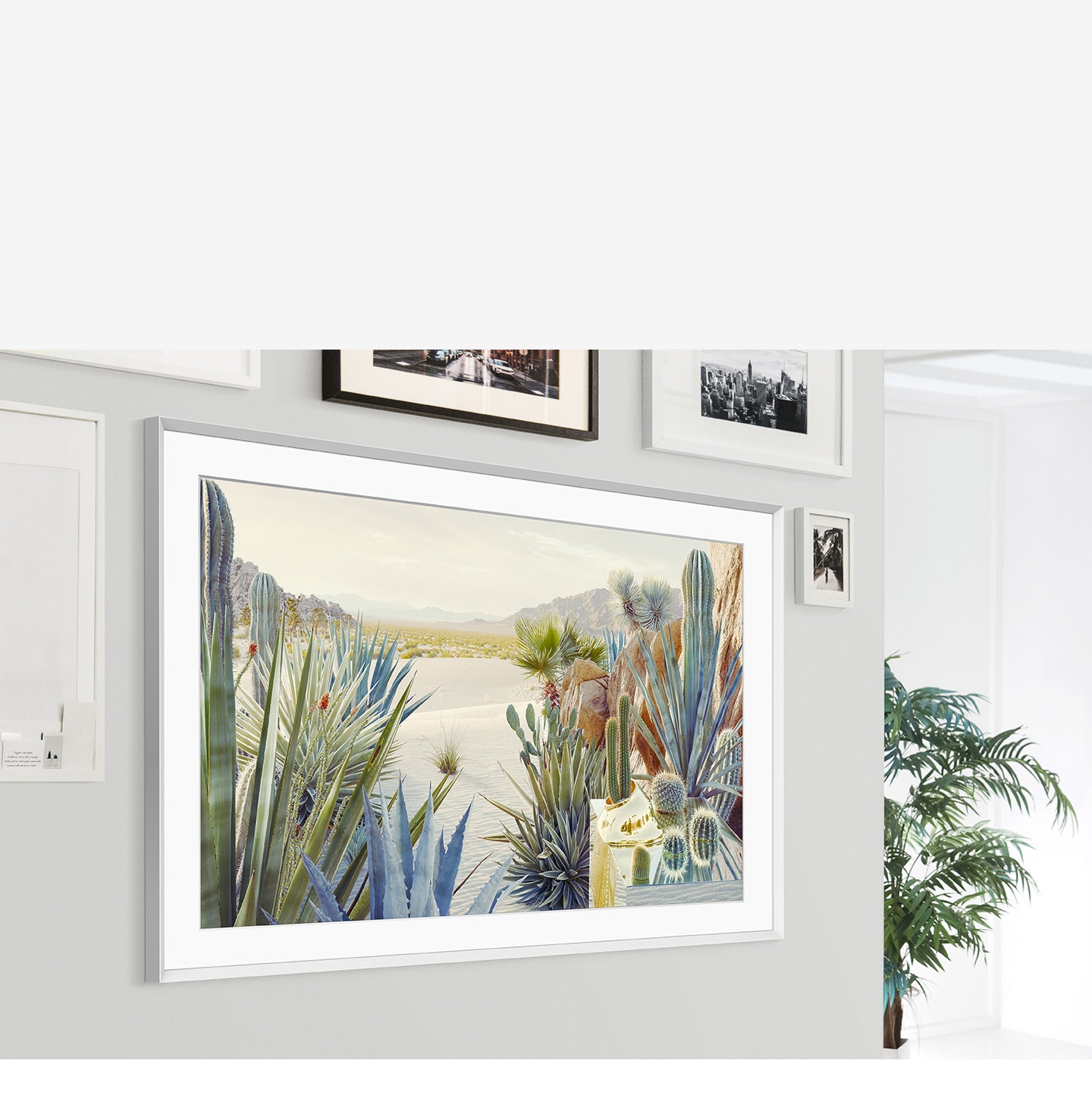 The Frame is mounted on the wall of a home interior and its modern frame design blends with the other picture frameson the wall.