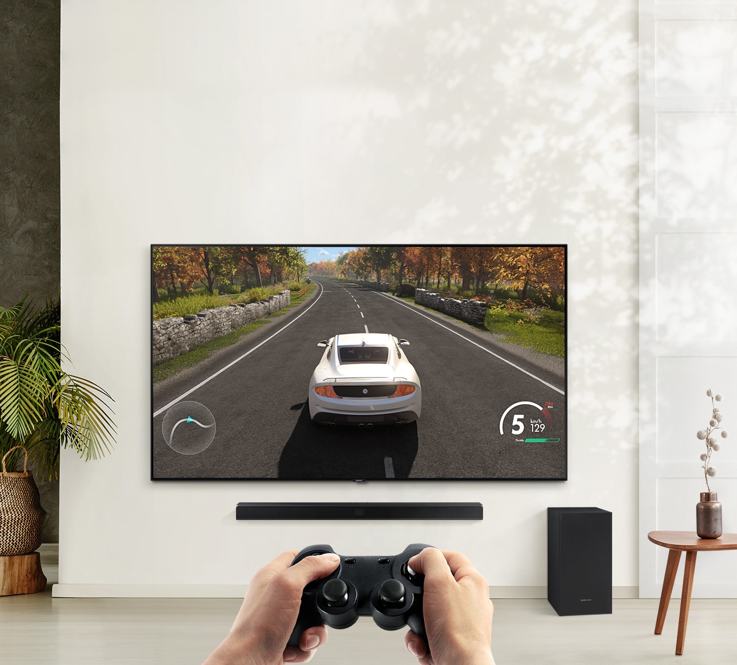 A user is enjoying soundbar’s Game Mode while playing a racing game on their TV connected to soundbar and subwoofer.