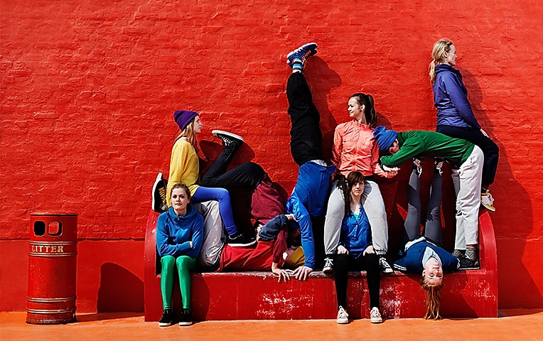 Группа людей на фоне красной стены