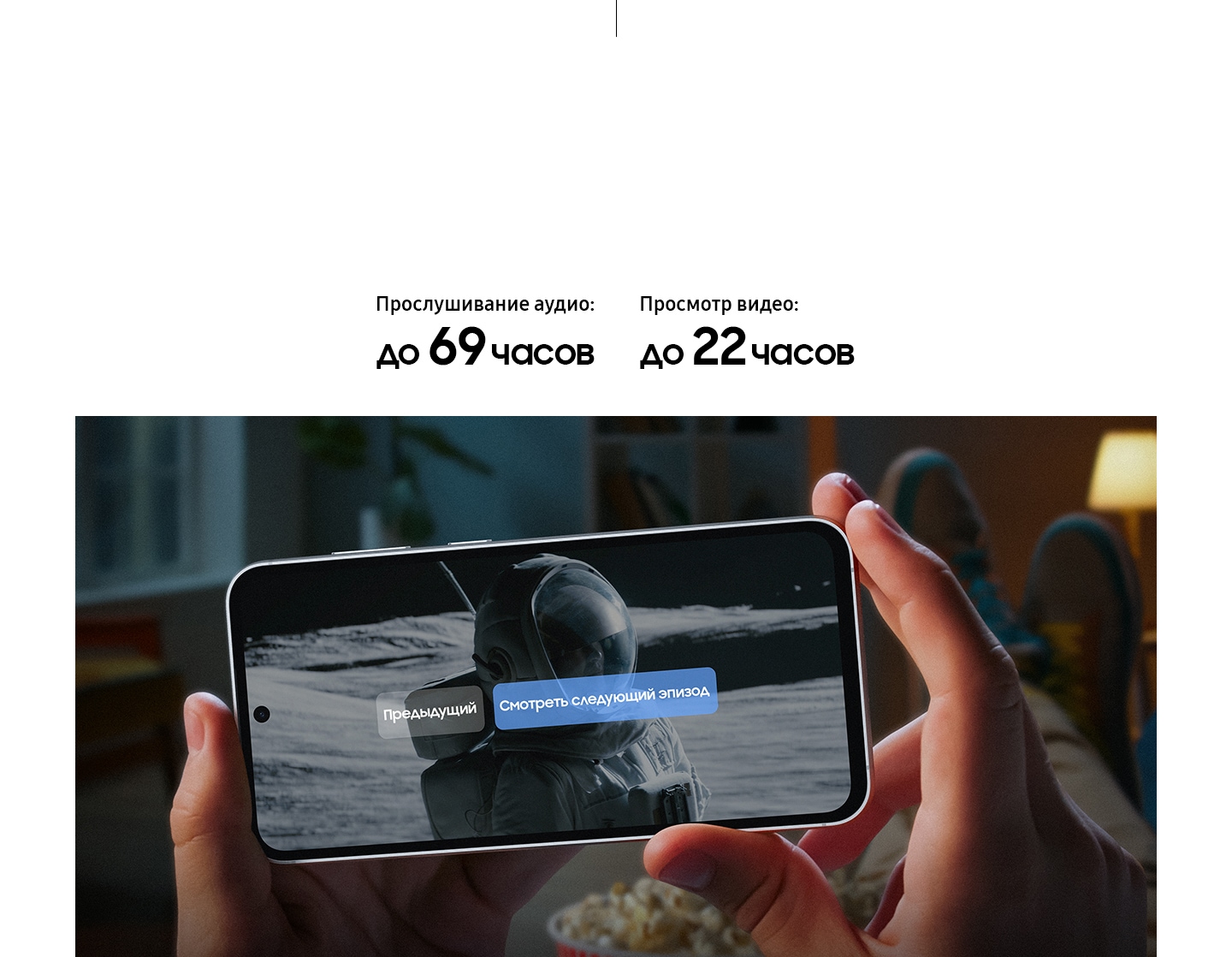 Устройство Galaxy S23 FE в руках пользователя; на экране отображается момент окончания сериала. Текст субтитров: "Смотрите следующий эпизод" подчеркивает факт, что устройство оснащено аккумулятором с увеличенной емкостью. 