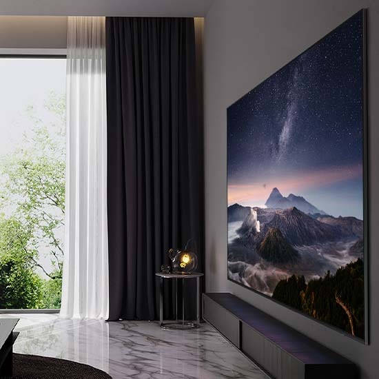 Телевизор NEO QLED с диагональю 98" закреплен на стене в гостиной и показывает вид на горы.