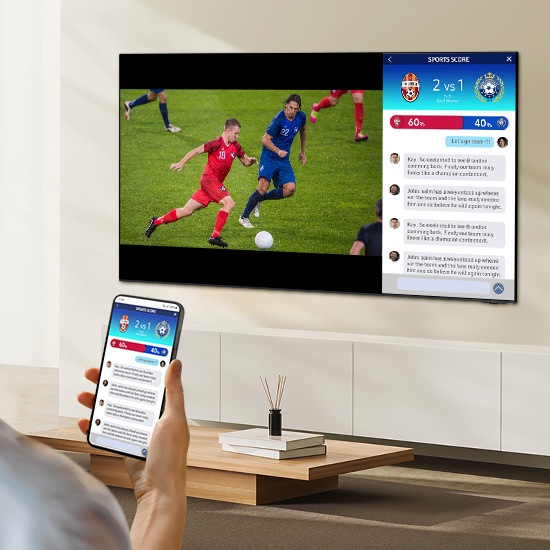 Человек одновременно смотрит на два разных экрана телевизора. У них есть один экран, на котором отображается футбольный матч, и второй экран, на котором отображается их мобильный телефон и статистика в реальном времени.