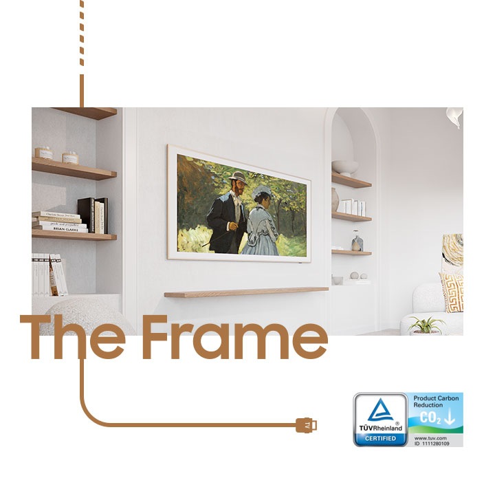 Рамка висит на стене в гостиной, на ней на экране изображена картина с изображением пары. Логотип Product Carbon Reduction от TUVRheinland CERTIFIED находится в правом нижнем углу.